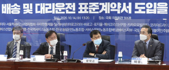 황덕순 청와대 일자리수석(오른쪽 두번째)이 지난 14일 국회 의원회관에서 열린 '이륜차 배송 및 대리운전 표준계약서 도입을 위한 협약식'에 참석한 모습.   연합뉴스